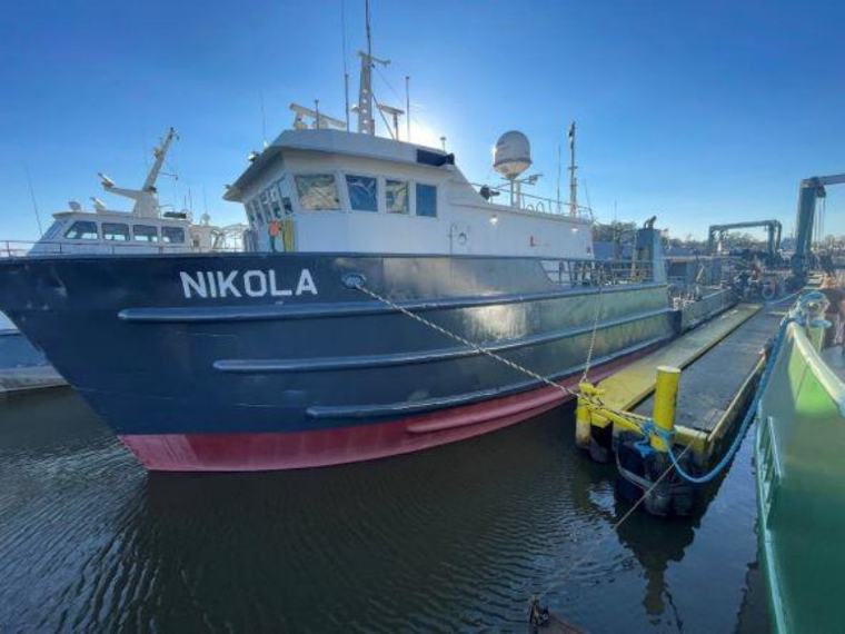 The M/V Nikola moored bow-on under a clear sky