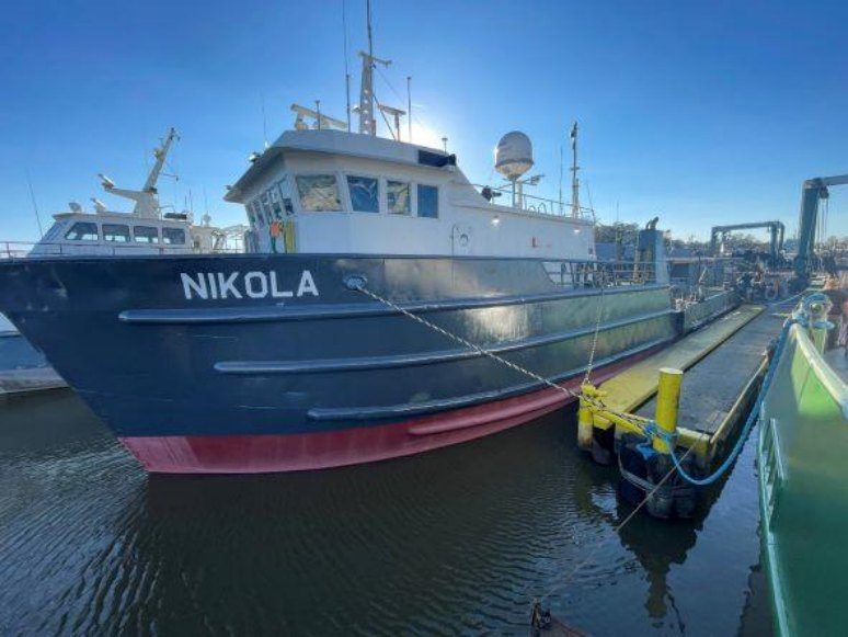 The M/V Nikola moored bow-on under a clear sky