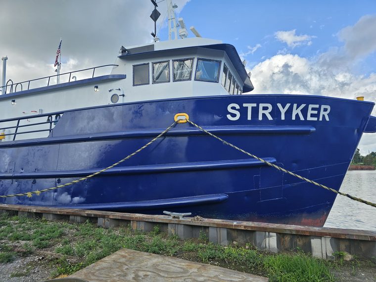 The name STRYKER in white block letters on the blue steel bow